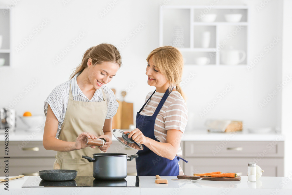 年轻女子和她的母亲一起在厨房做饭