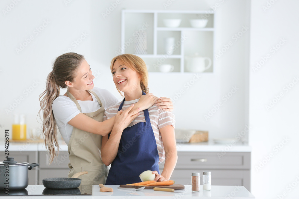 年轻女子和她的母亲一起在厨房做饭