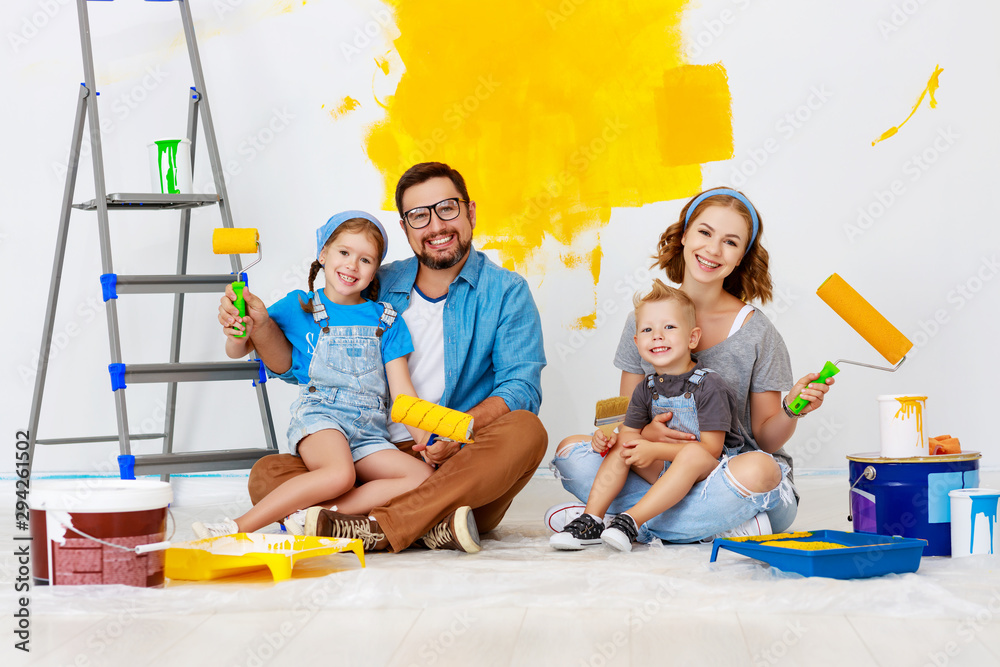 Repair in apartment. Happy family mother, father and children   paints wall .