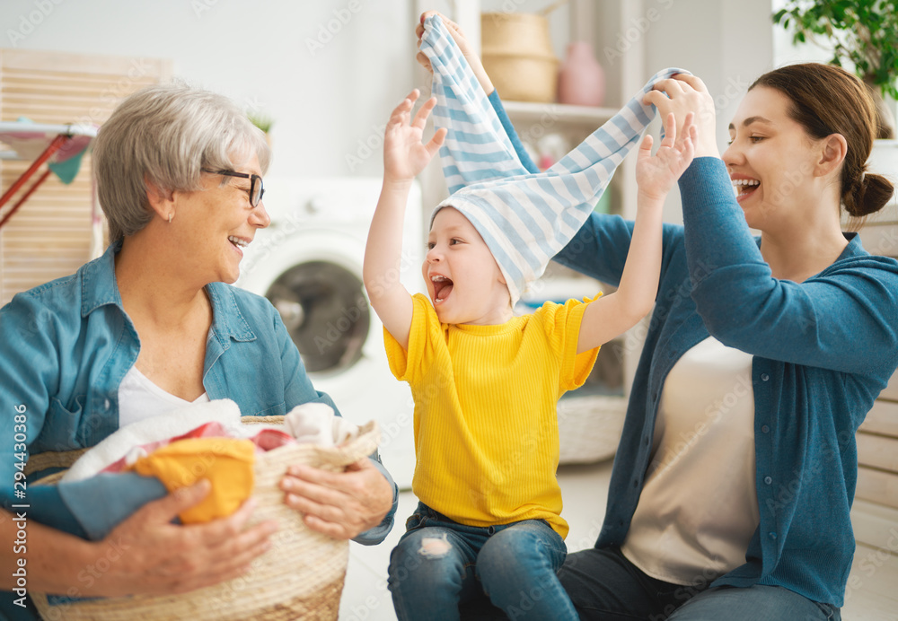 grandma, mom and child are doing laundry