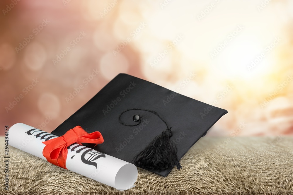 Graduation mortarboard on  book on  background