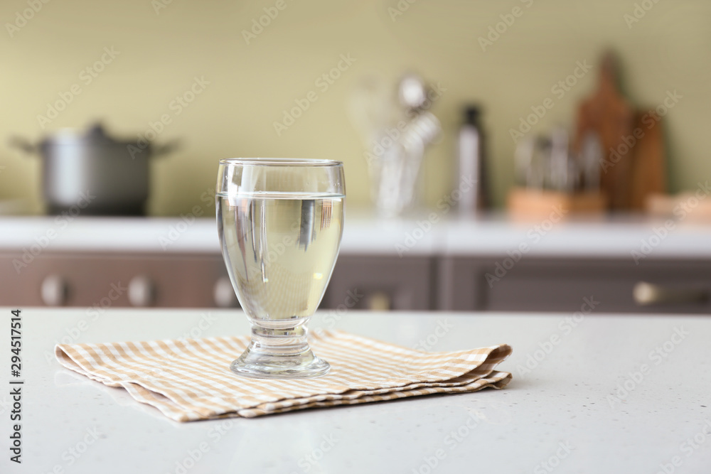 Glass of fresh water on table in kitchen