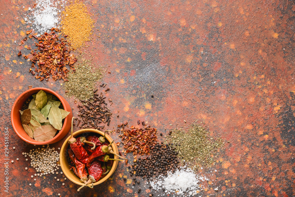 Bowls with different spices on color background