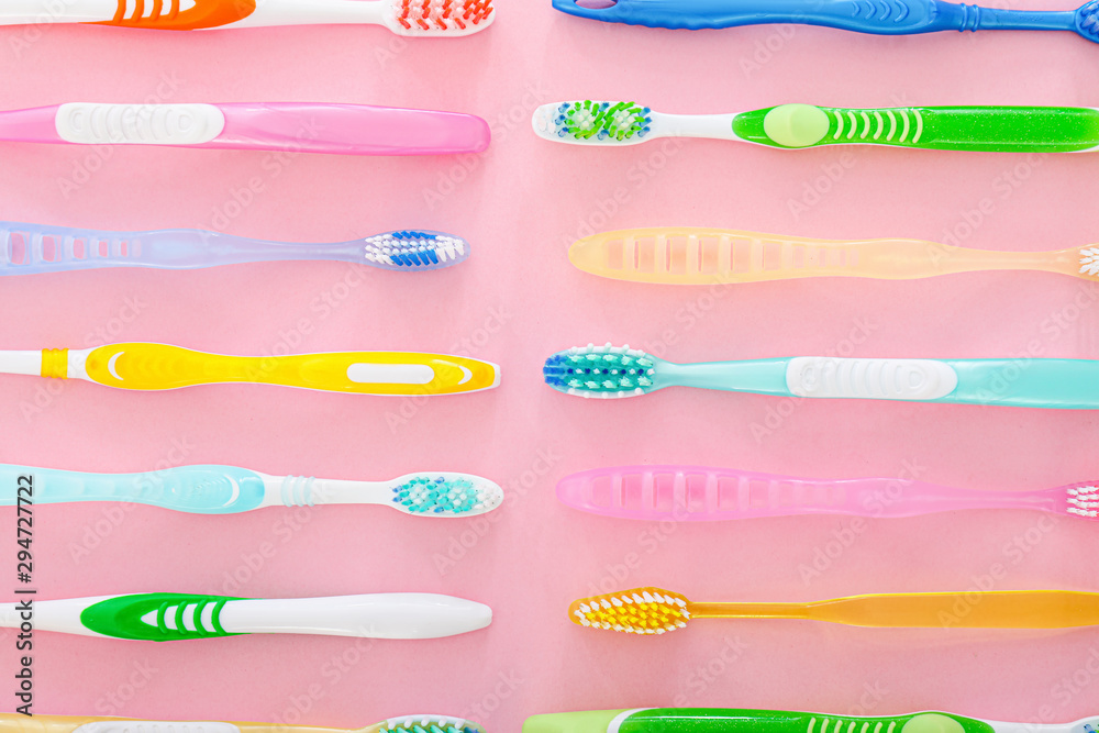 Many different tooth brushes on color background