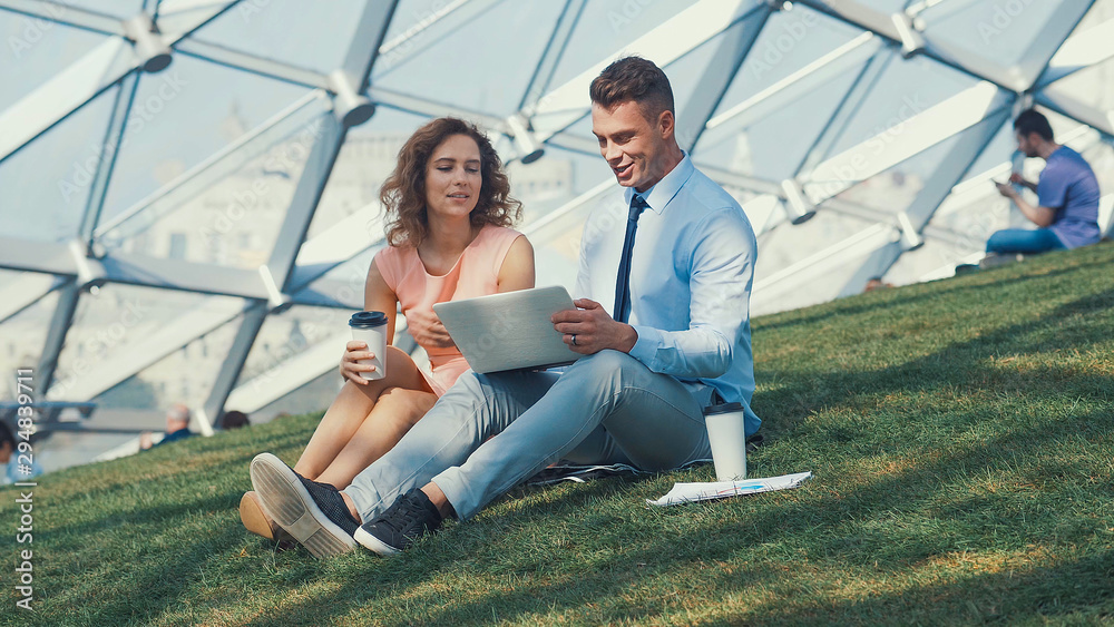 Working couple with laptop outdoors