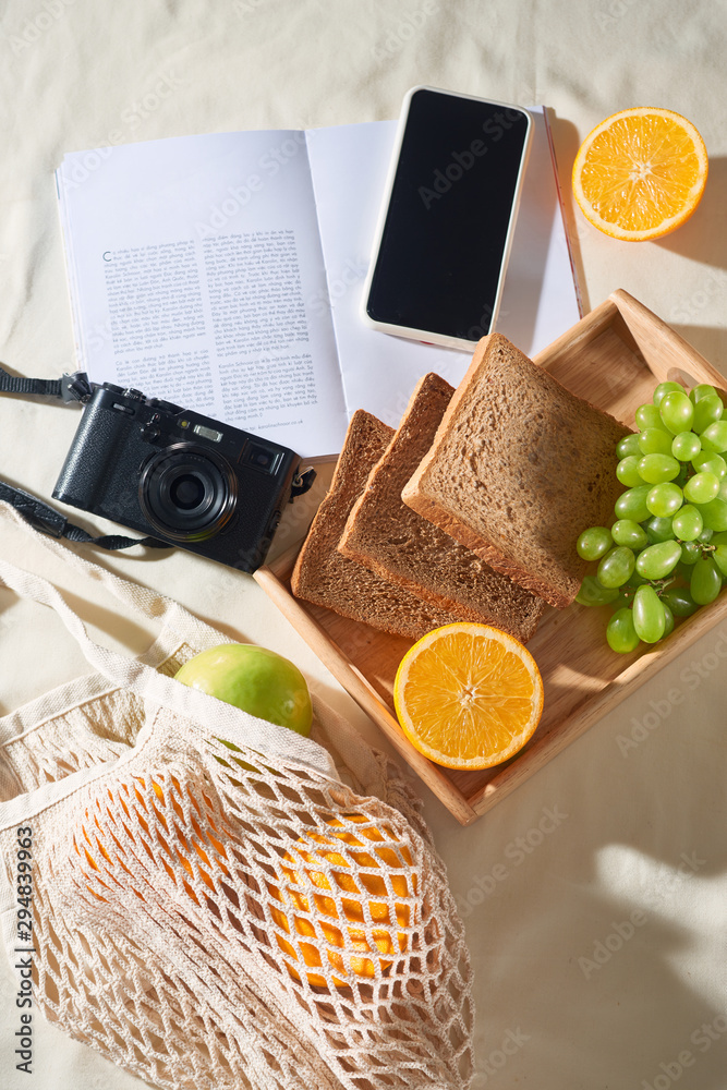 Phone, camera, fruit, bag, notebook and accessories, top view, Flat lay, The concept of a picnic, su