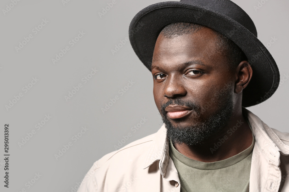 Portrait of handsome African-American man on grey background