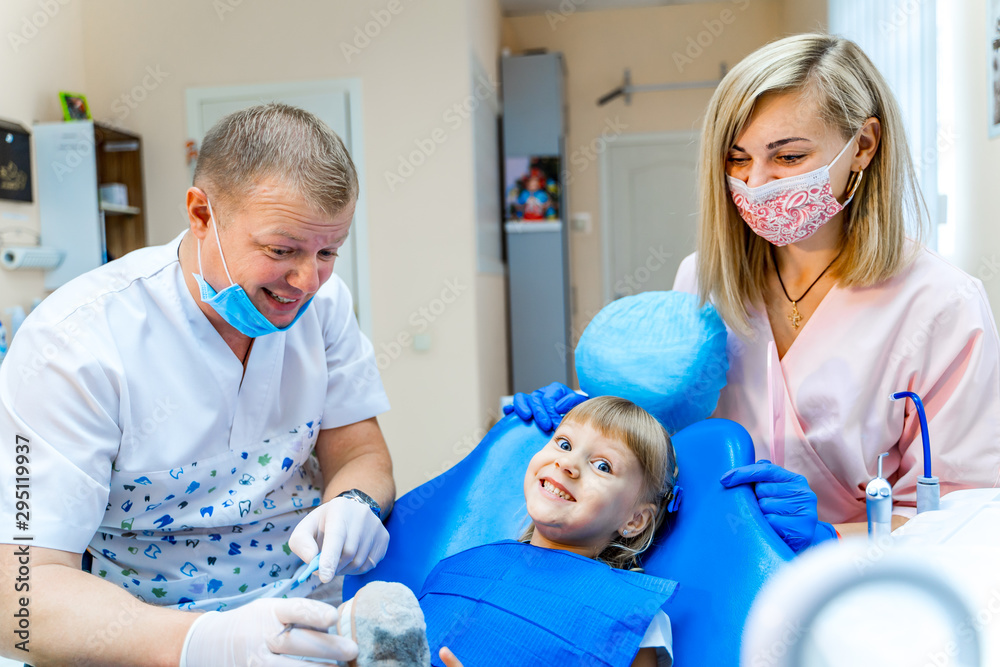 Little girl at the dentist cabinet. Dentist team working. Stomatology.