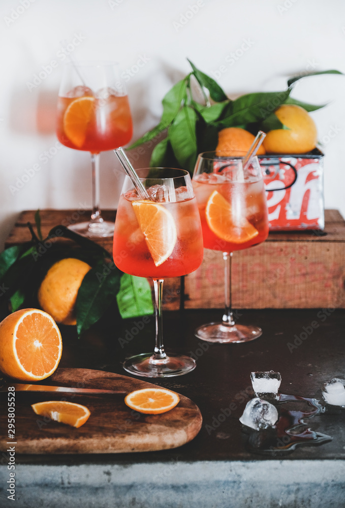 Aperol雪碧开胃酒酒精冷饮，装在玻璃杯里，配橙子和冰块，放在混凝土桌子上，w