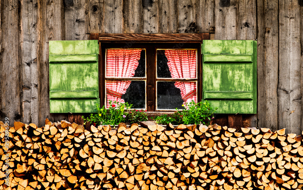 Fenster einer almhütte mit karierten Gardinen