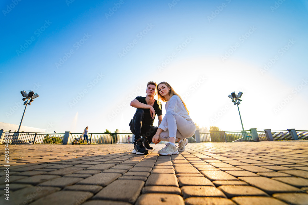 一对年轻夫妇在岩石路上摆姿势。坐在一起。女孩和男孩蹲在一起。电影