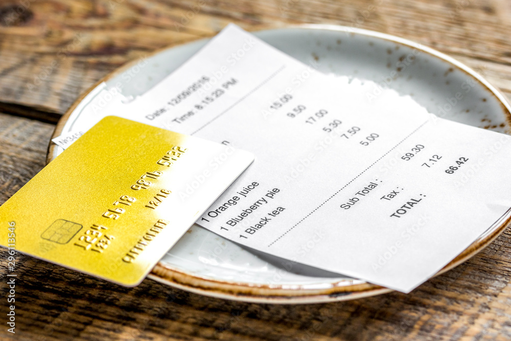 paying check for lunch with card wooden table background