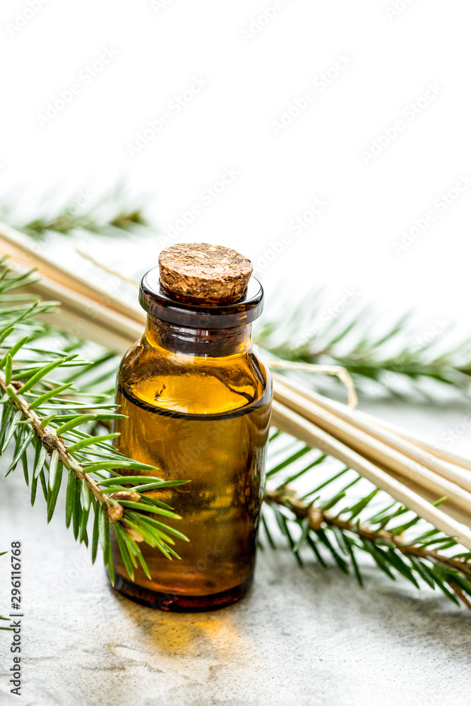 fir branches and spruce aroma oil on white table background