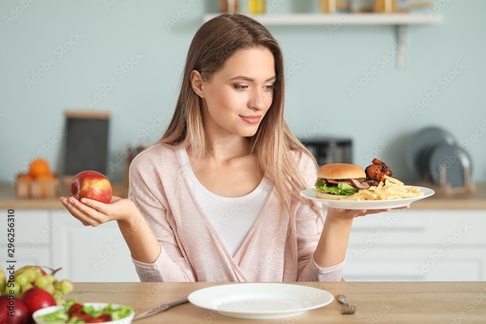 女性在厨房里选择健康和不健康的食物。饮食概念