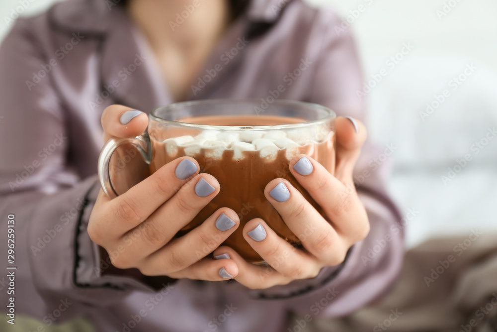 年轻女子拿着一杯热巧克力，特写镜头