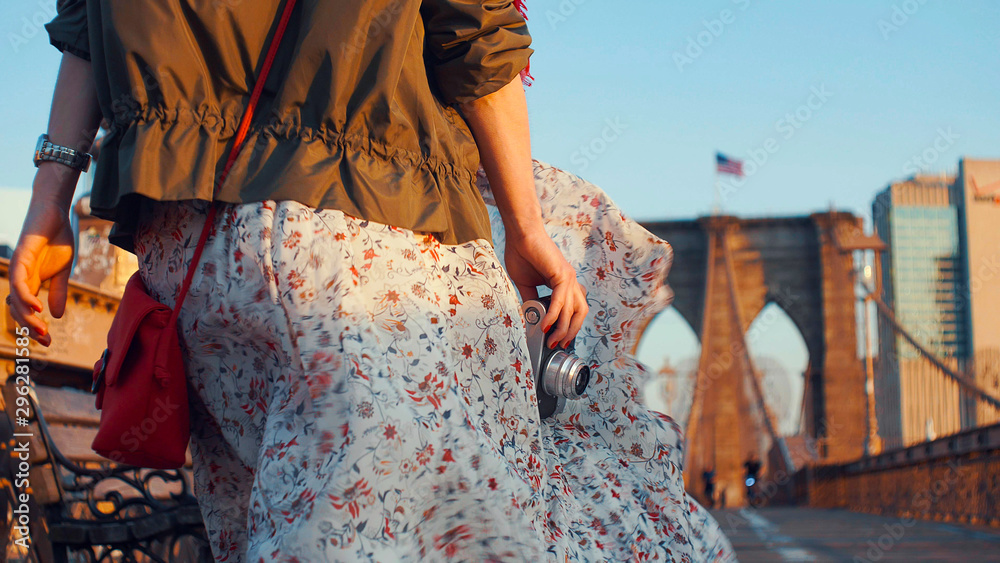 Young woman with a retro camera on the Brooklyn Bridge