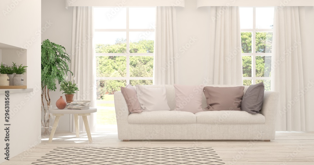 Stylish room in white color with sofa and summer landscape in window. Scandinavian interior design. 