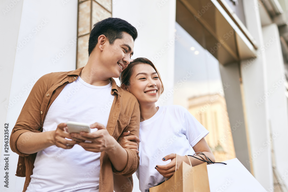 Happy beautiful couple using smart phone and shopping together.