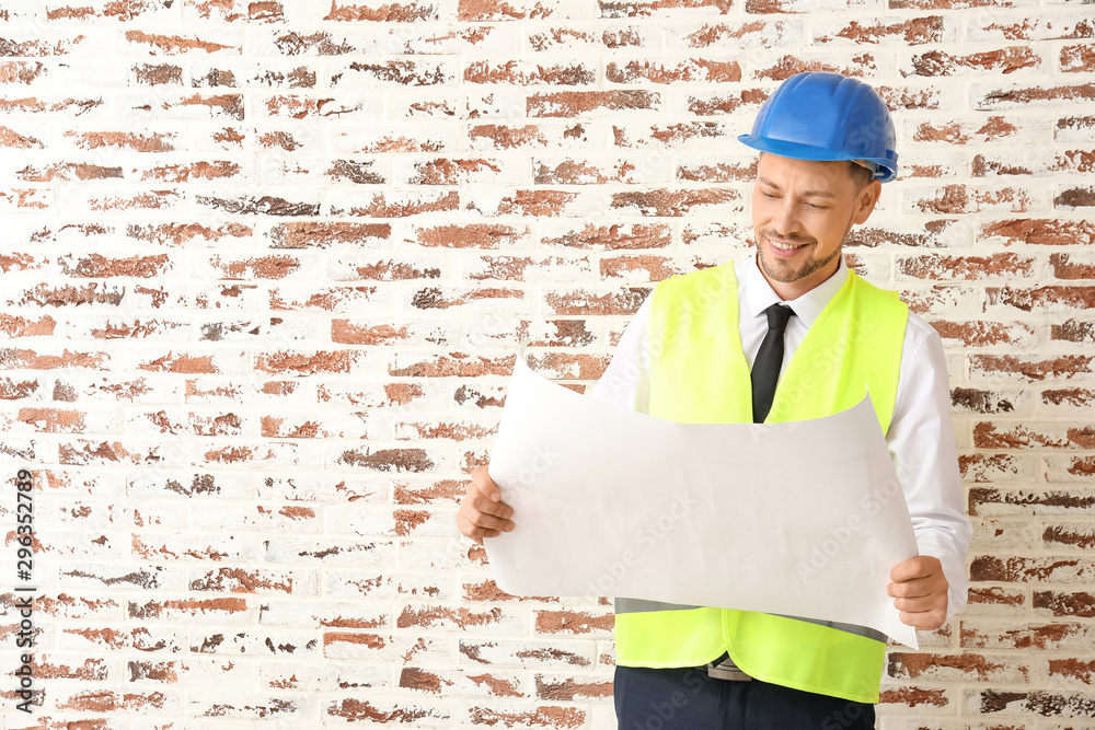 Portrait of male architect against brick wall