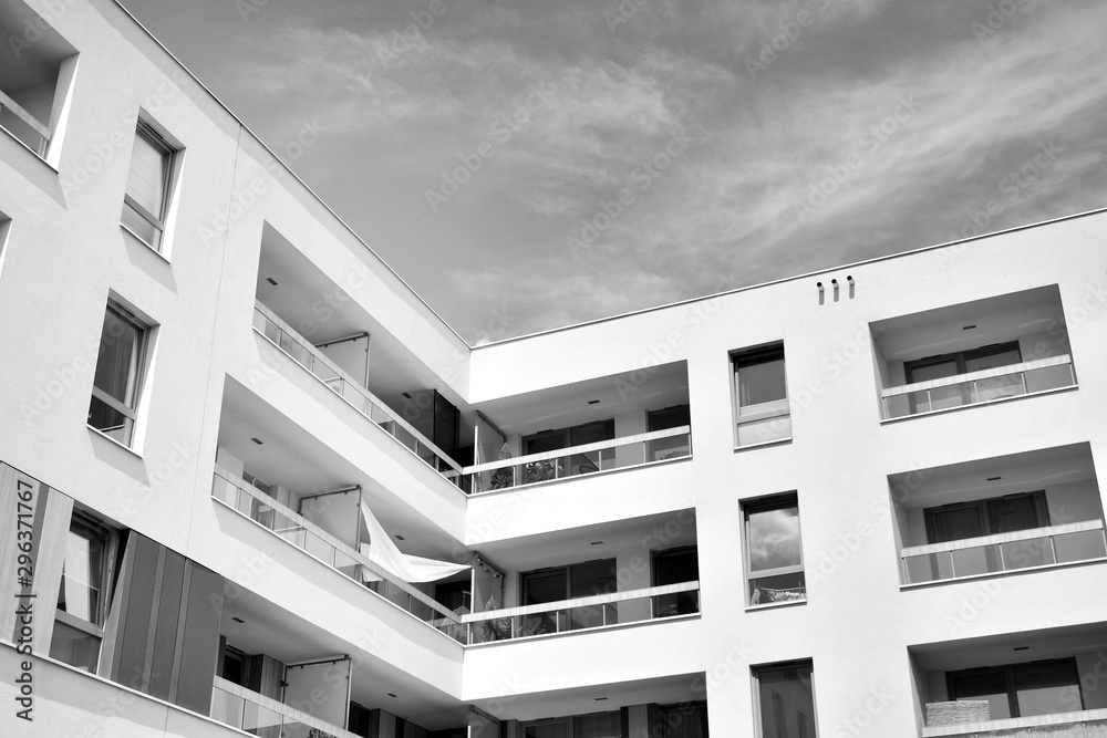 Fragment of a facade of a building with windows and balconies. Modern home with many flats. Black an