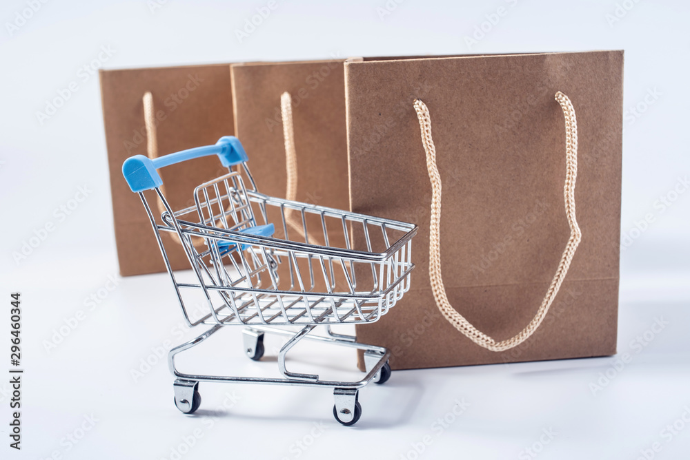 Shopping cart and kraft shopping bag consumption online shopping concept illustration on white backg