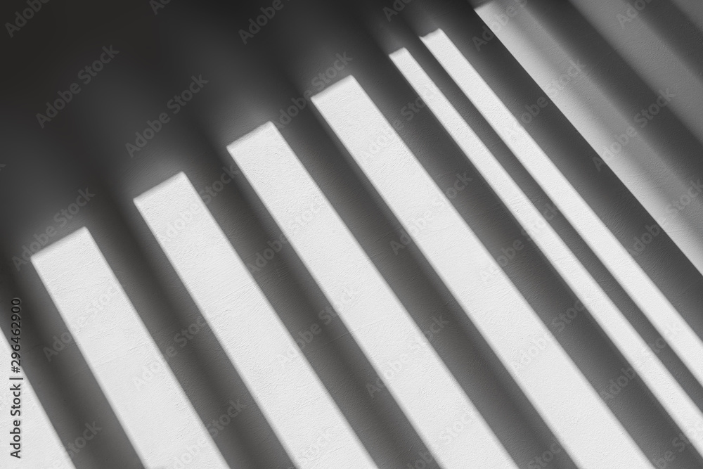 abstract shadow batten of lath and morning light on white concrete wall texture background