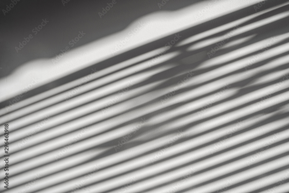 abstract shadow batten of lath and morning light on white concrete wall texture background