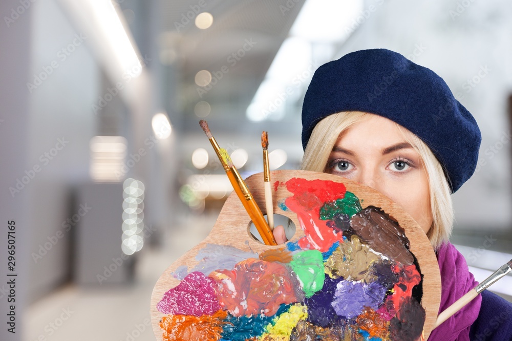 Young beautiful woman with painted  face and paintbrushes