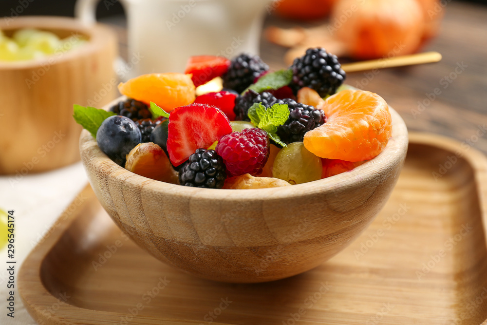 Bowl with tasty fruit salad on table