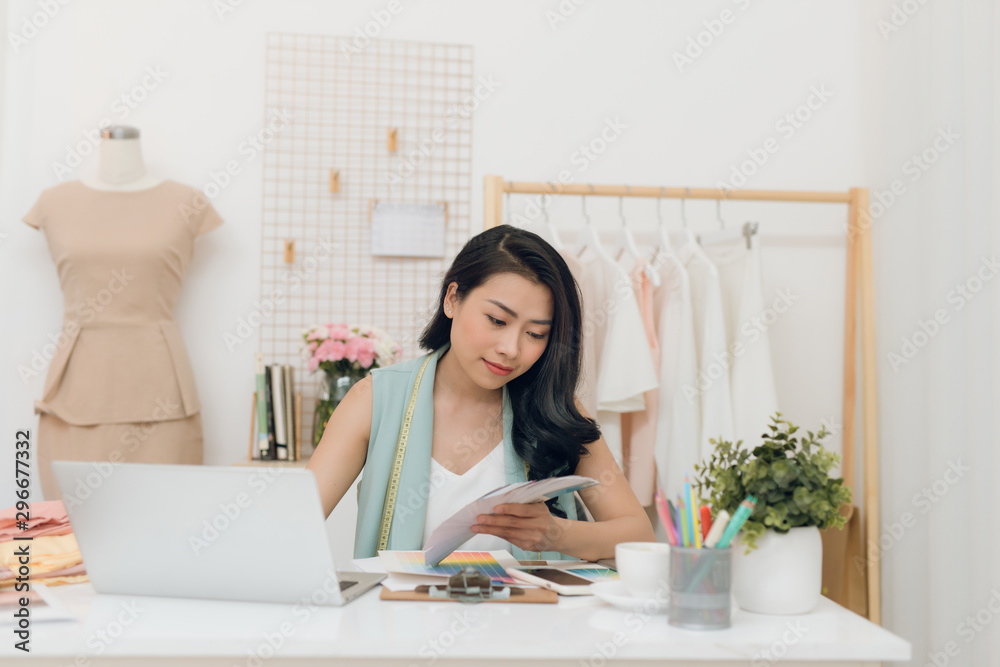 Young Asian fashion designer choosing color for her new collection