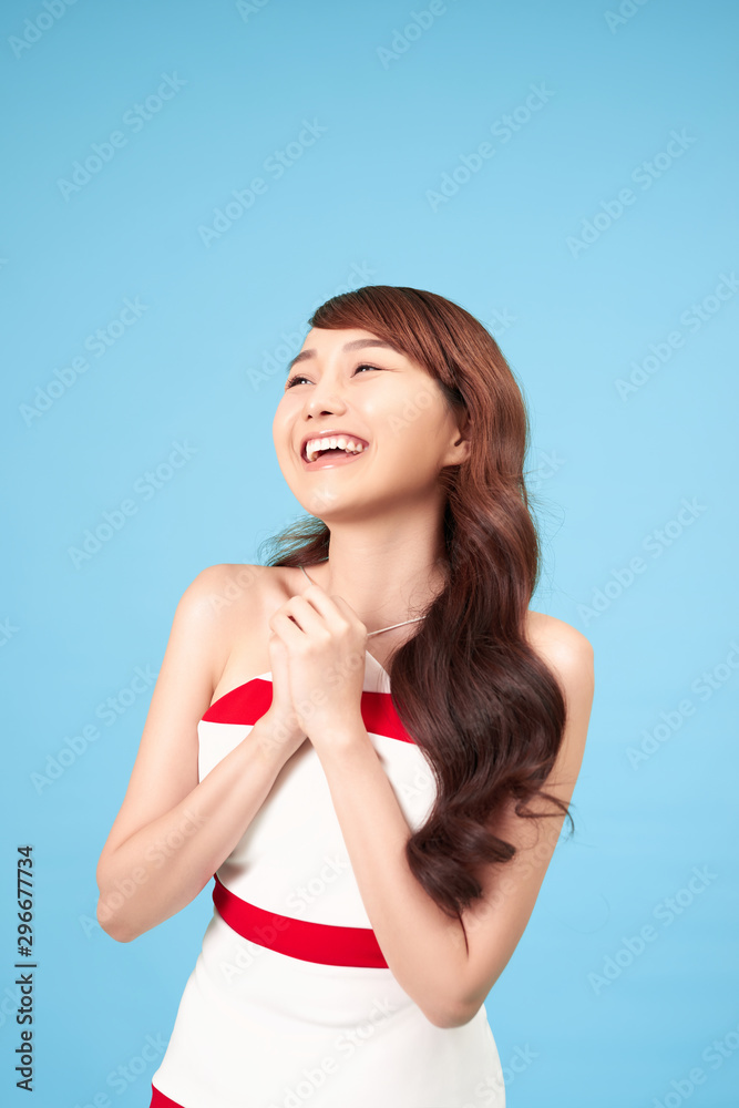 Asian woman happy with special deals & discounts of promotions on blue background