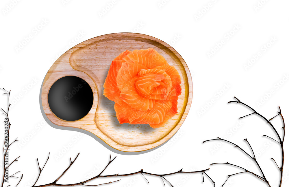 fresh salmon in rose shape with soy sauce in wooden plate and dry branchs isolated on white backgrou