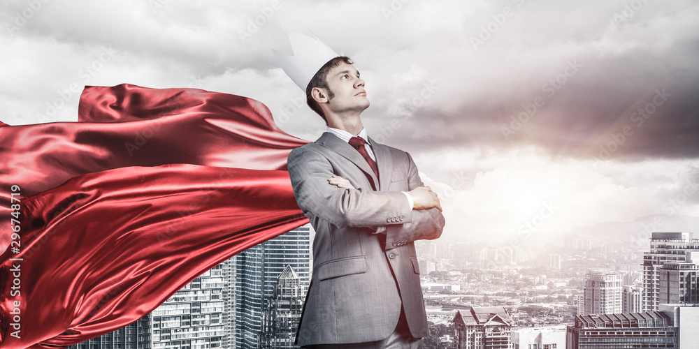 Concept of power and sucess with businessman superhero in big city