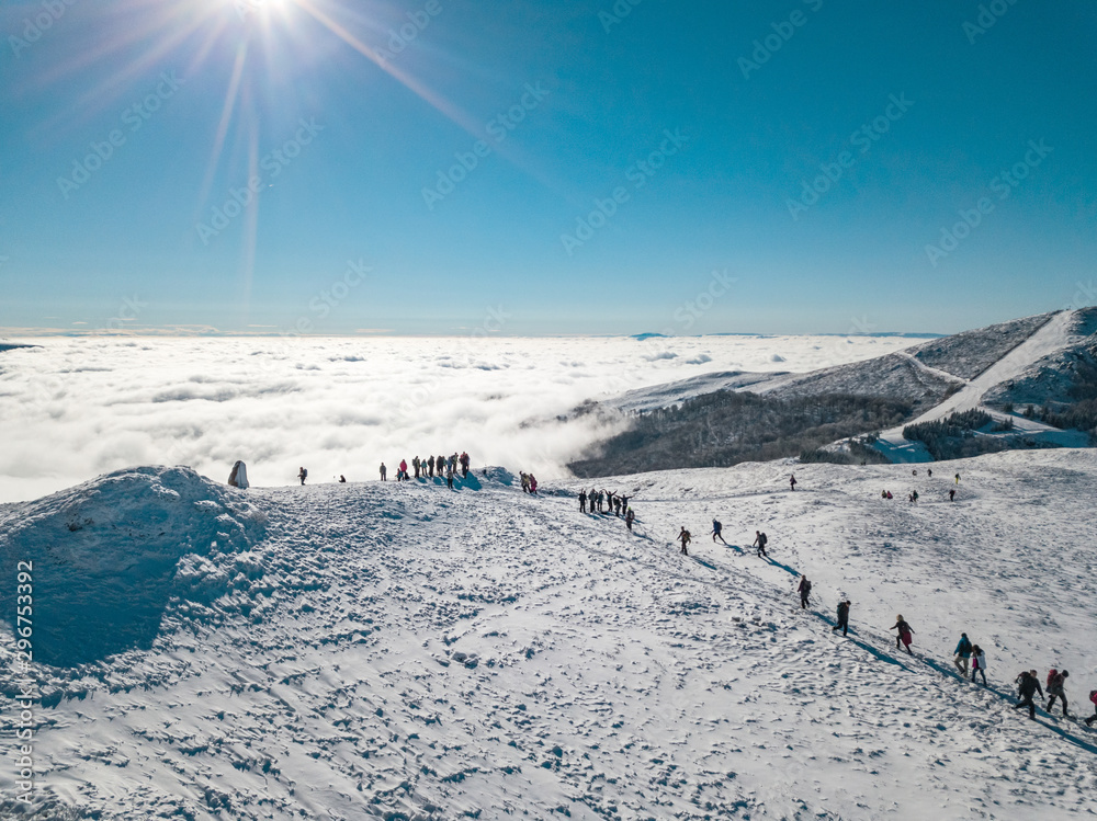 登上白雪皑皑的山顶的登山者。欧洲冬季积雪覆盖的山峰。