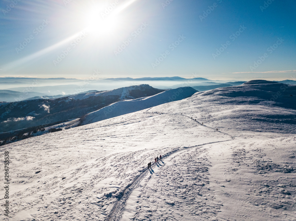 雪山、山峰和一群徒步旅行者的晴朗冬季景观。