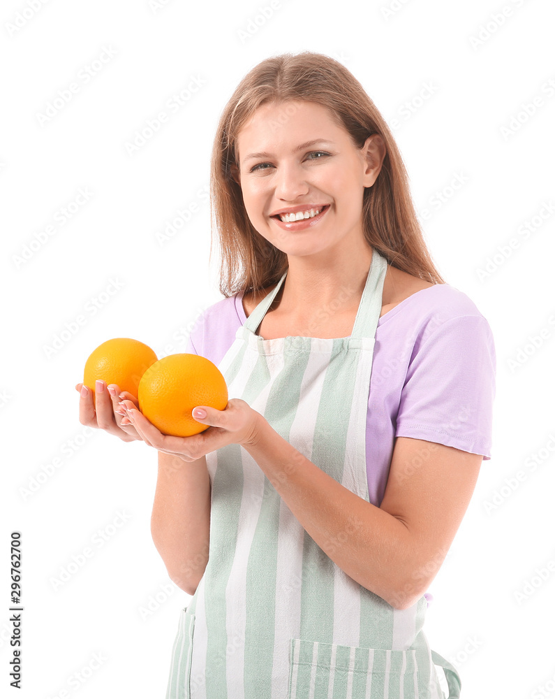 Beautiful young woman in apron and with oranges on white background