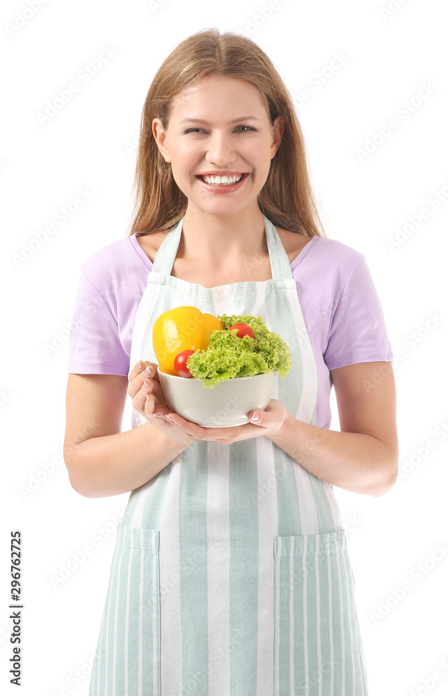 Beautiful young woman in apron and with vegetables on white background