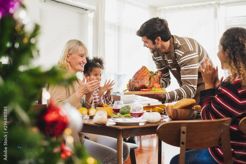 Happy Thanksgiving dinner party with family and food with turkey on table