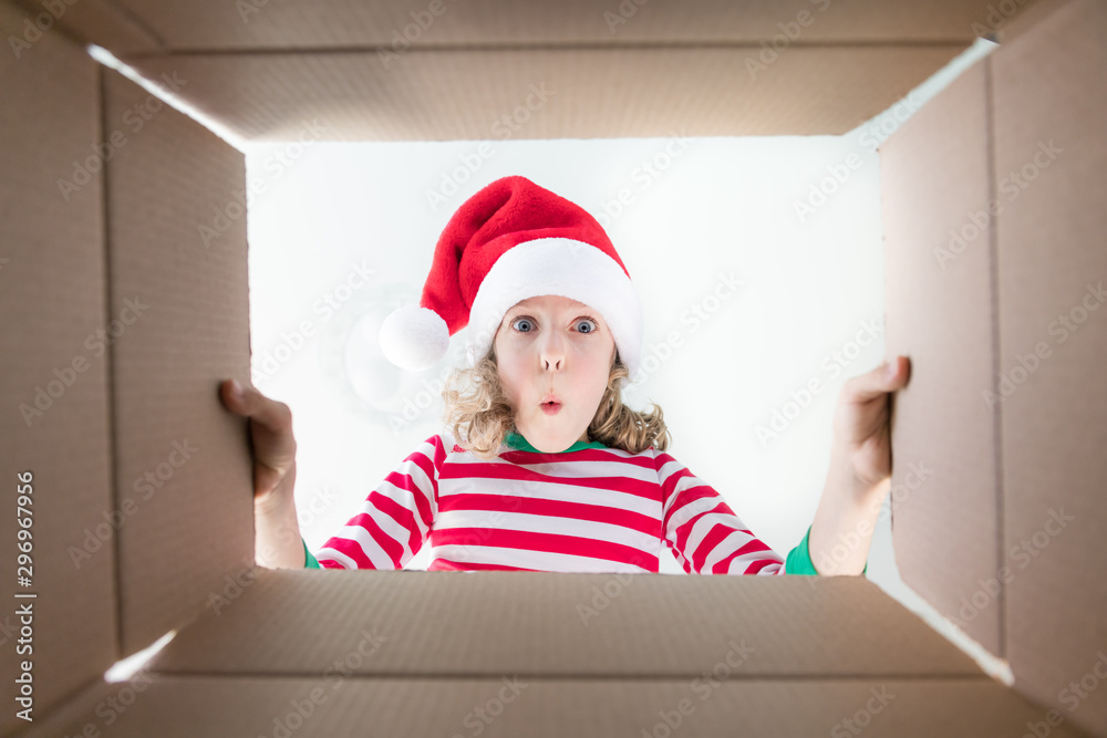 Surprised child unpack Christmas gift box