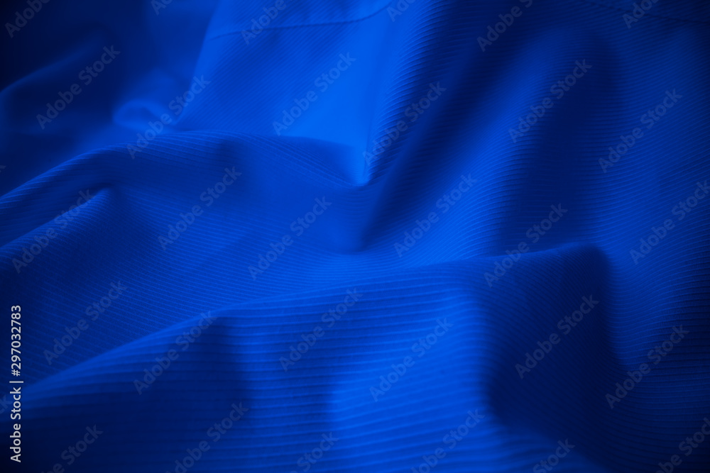 Shiny flowing cloth texture in macro shot. Wavy clean silk weave material. Textile abstract backgrou