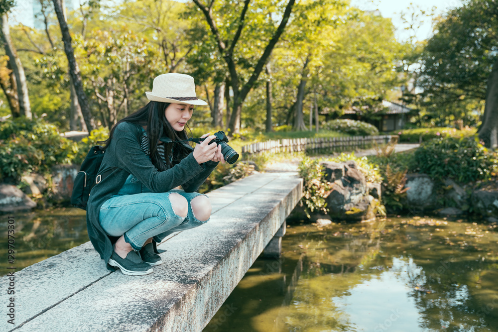 女摄影师跪在石桥上