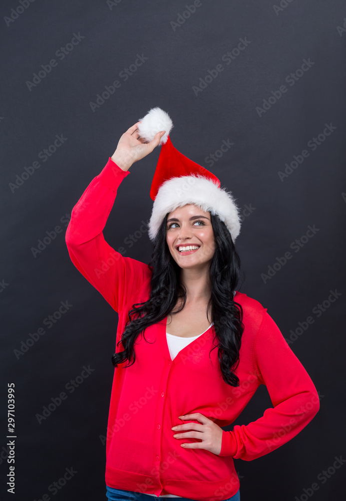 Young woman with a Santa hat on a black background