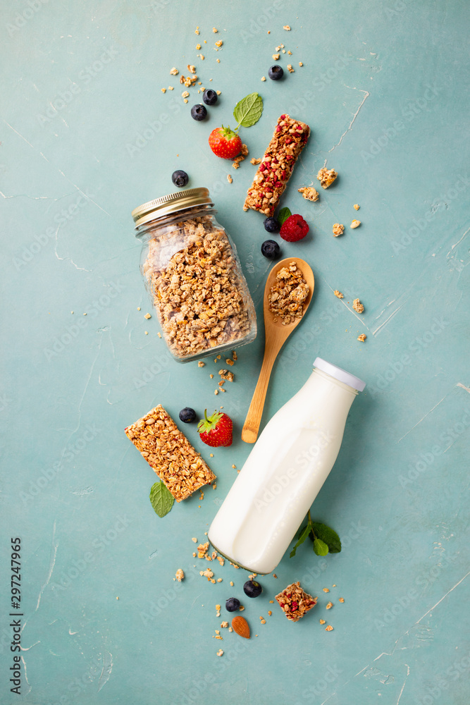 Home granola in a glass jar on blue concrete background