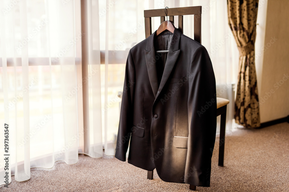 Preparations for the wedding. Grooms jacket on the holder. Wedding photo concept closeup.