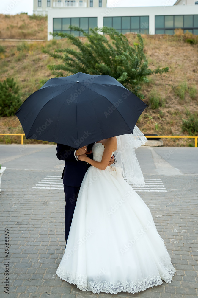 Bride and groom at wedding Day walking Outdoors. Bridal couple, Happy Newlywed woman and man under u