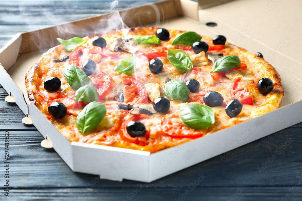 Box with tasty Italian pizza on wooden table