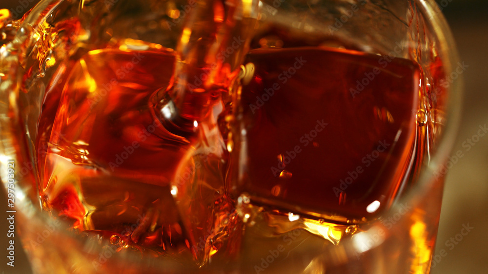 Super macro shot of pouring spirit into glass