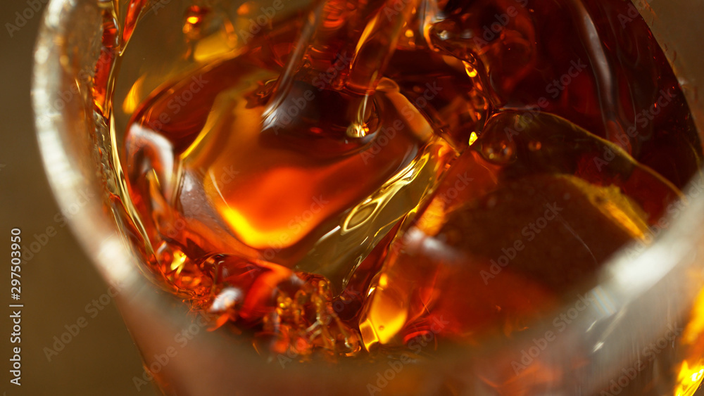 Super macro shot of pouring spirit into glass