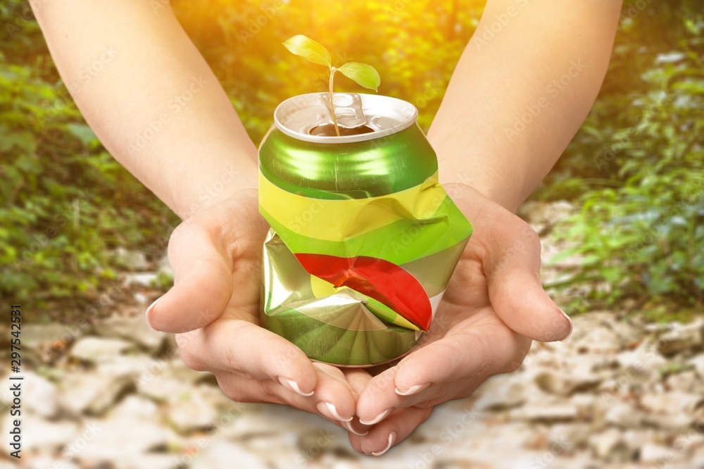 Hands holding metal can on background