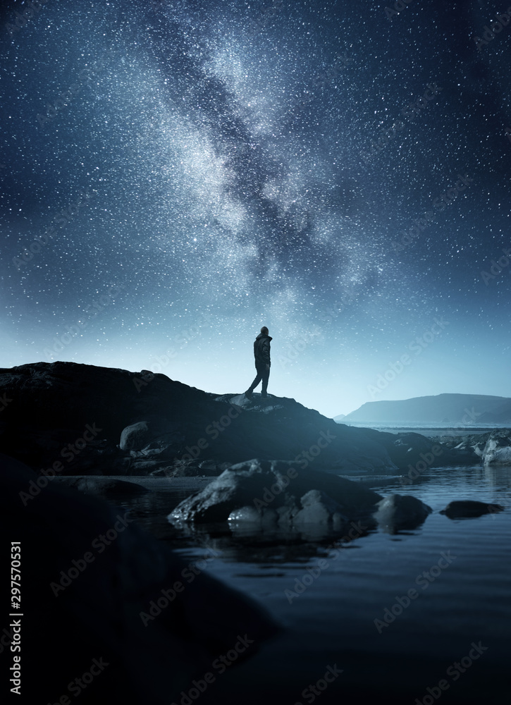 Calm Midnight adventures. A long exposure shot of a man staring up into the night sky, silhouetted a